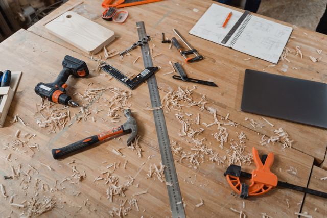 Tools, shavings and a drawing laid out on a workbench mid-project